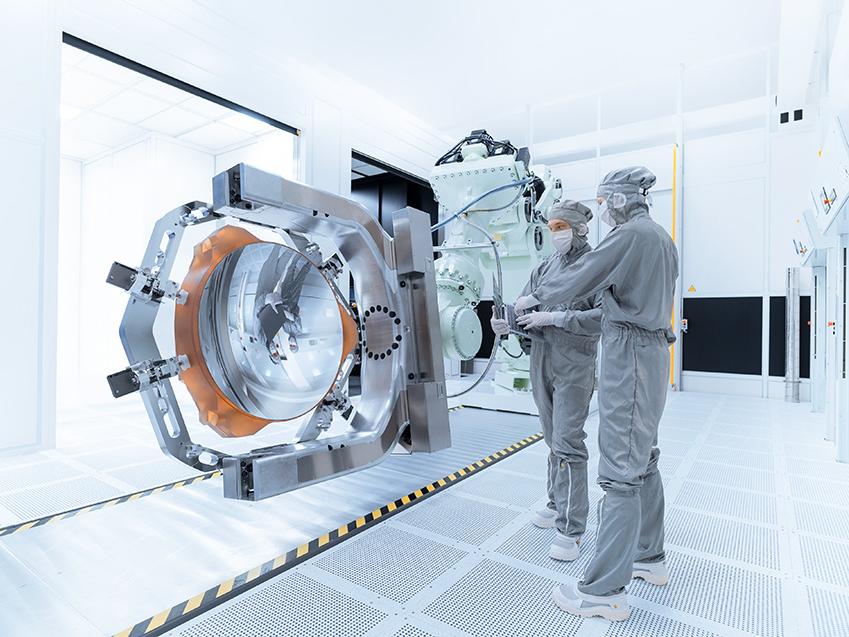 Zwei Mitarbeiter arbeiten an einem Spiegel der High-NA-EUV-Technologie im Reinraum