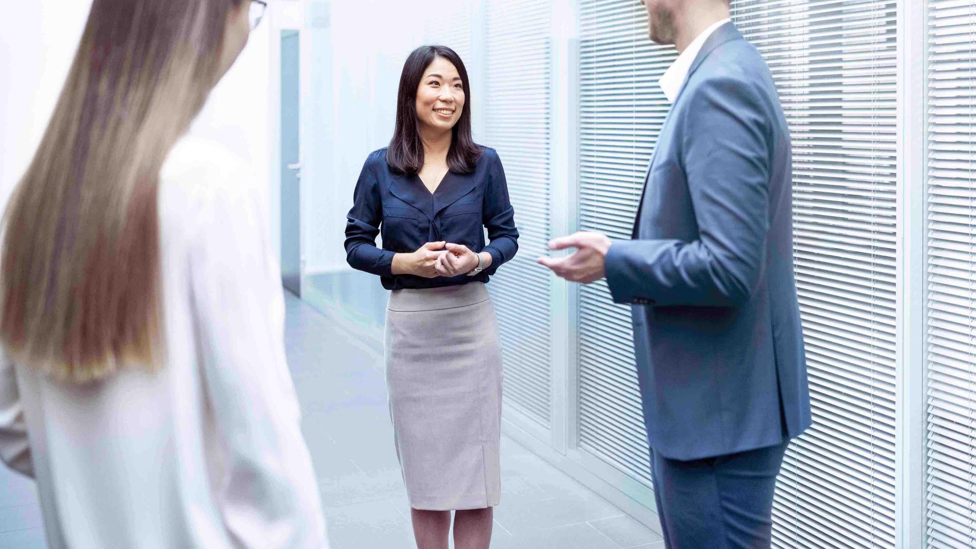 Mitarbeiter sprechen im Gang der ZEISS SMT miteinander 