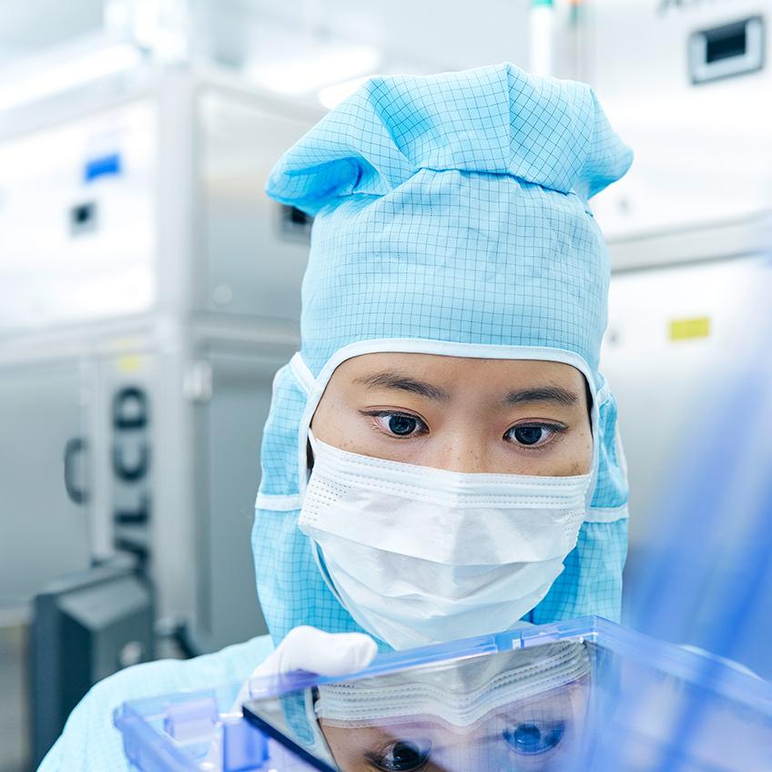 Eine ZEISS Mitarbeiterin arbeitet an einer Photomaske im Reinraum.