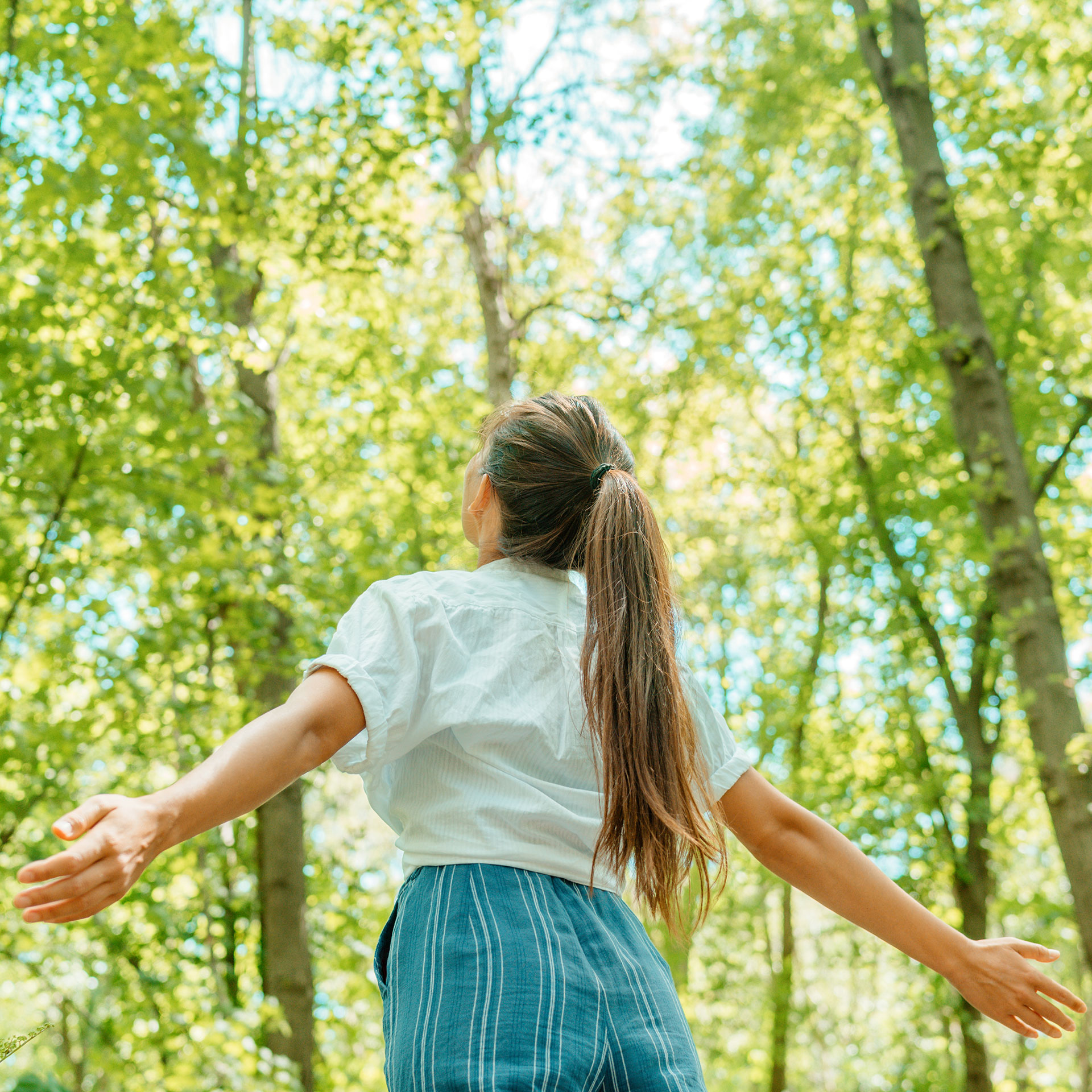 Frau, die saubere Luft im Wald atmet