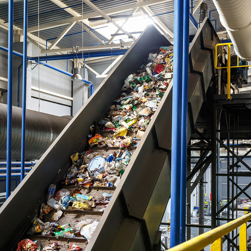 Beweglicher Fördertransporter auf einer modernen automatisierten Recyclingverarbeitungsanlage. Getrenntes und sortiertes Einsammeln von Müll. Recycling und Lagerung von Abfällen zur weiteren Entsorgung.