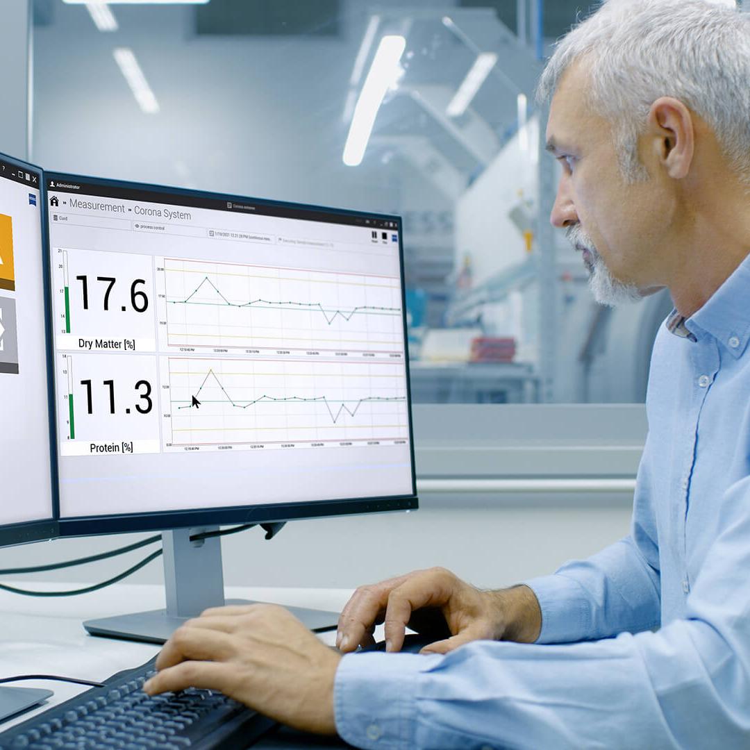 Ingenieur sitzt vor dem Computer in einer Produktionsumgebung in seinem Büro, die Bildschirme zeigen die Oberfläche der InProcess-Software 