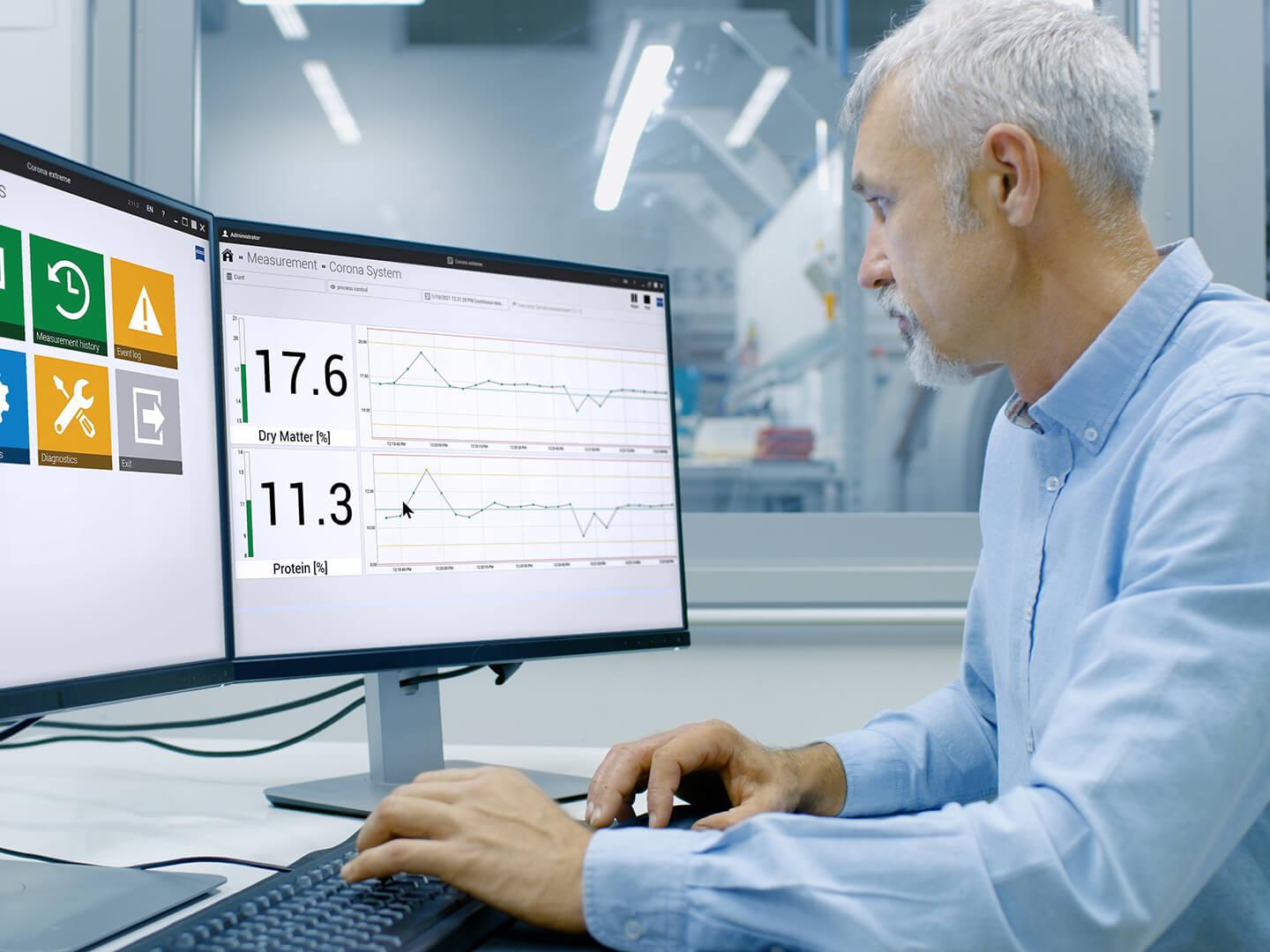 engineer sits in front of the computer in a production environment in his office, the screens show the interface of the inprocess software 