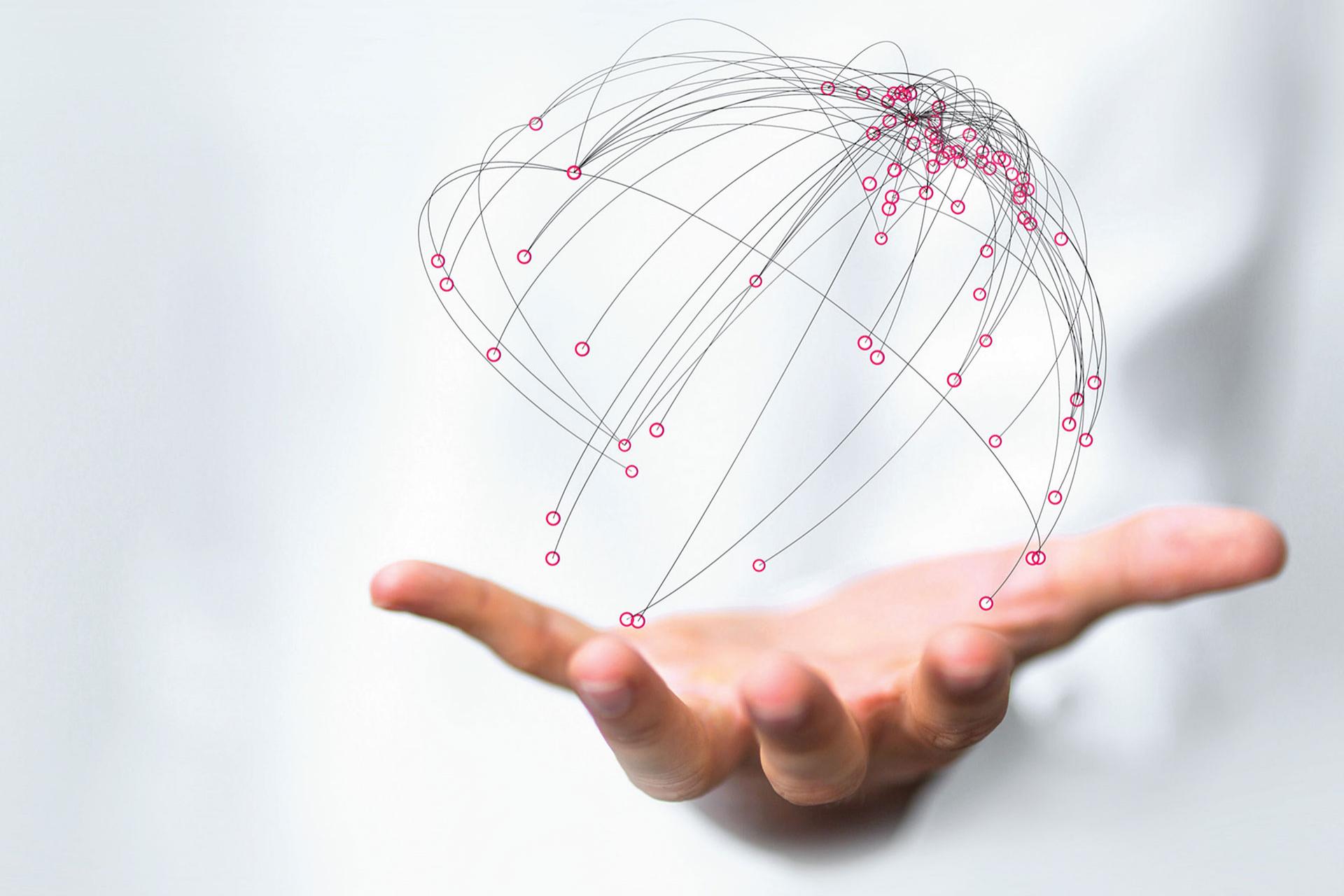 Connection around the world and between networks and production illustrated by connected dots forming a globe, hovering over a mans hand