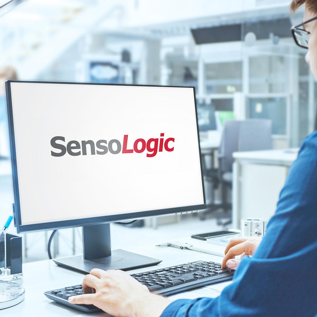 Blick über die Schulter eines Ingenieurs, der mit SensoLogic Software an einem Computer arbeitet. Im Hintergrund technische Anlage mit Industriedesign