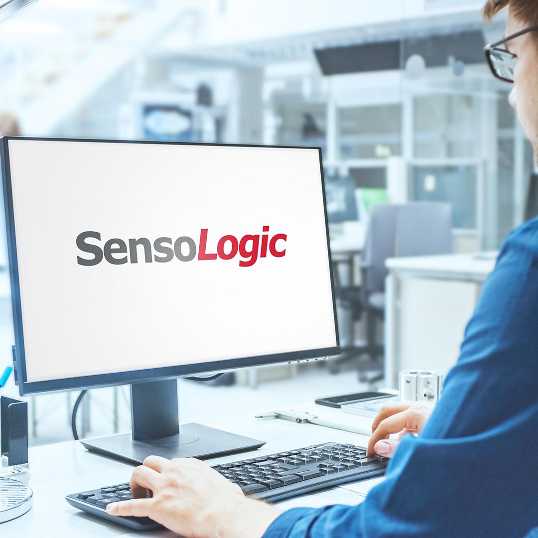 Blick über die Schulter eines Ingenieurs, der mit SensoLogic Software an einem Computer arbeitet. Im Hintergrund technische Anlage mit Industriedesign