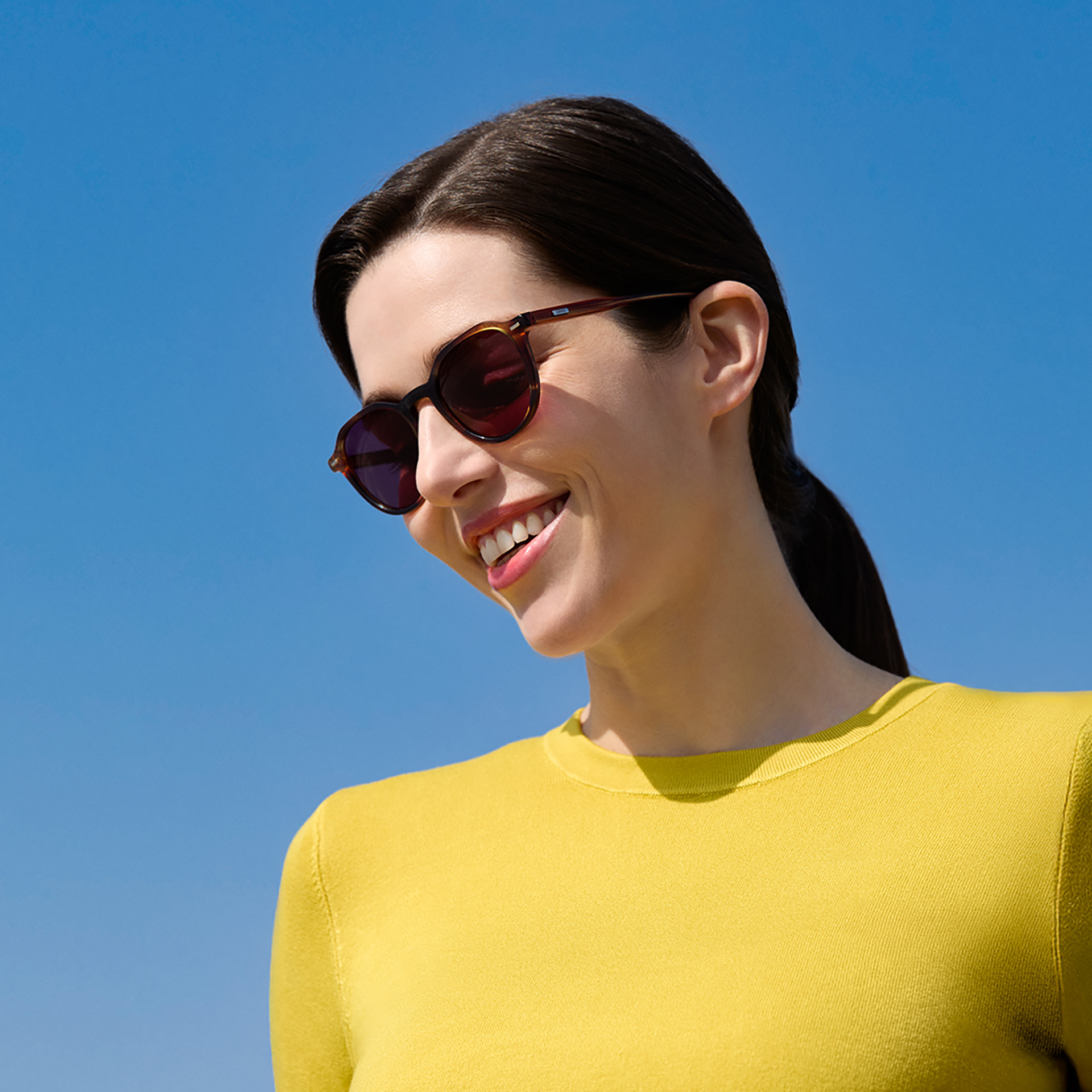 Eine Frau trägt eine Sonnenbrille mit Sehstärke in Burgund.