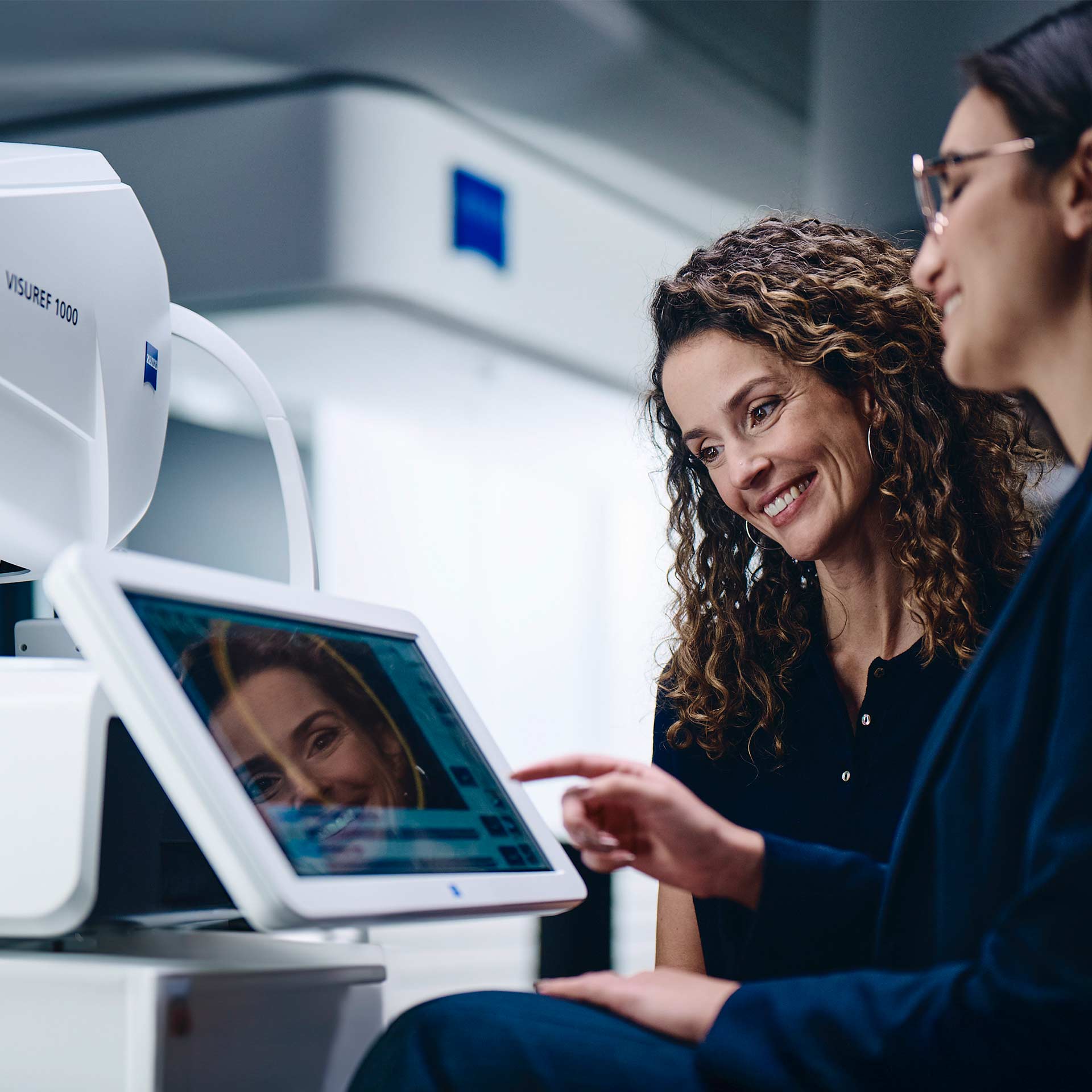 Zwei Frauen blicken auf den Bildschirm des ZEISS VISUREF 1000.