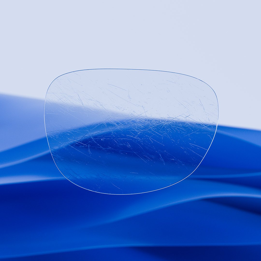 Ein Brillenglas im Vergleich: Eine Seite kristallklar mit ZEISS DuraVision, die andere mit unschönen Kratzern.