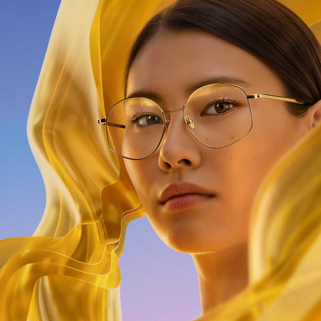 Eine Frau trägt Brillengläser mit der ZEISS DuraVision Gold UV Antireflexbeschichtung, die den dezenten goldenen Reflex auf dem Glas zeigt.