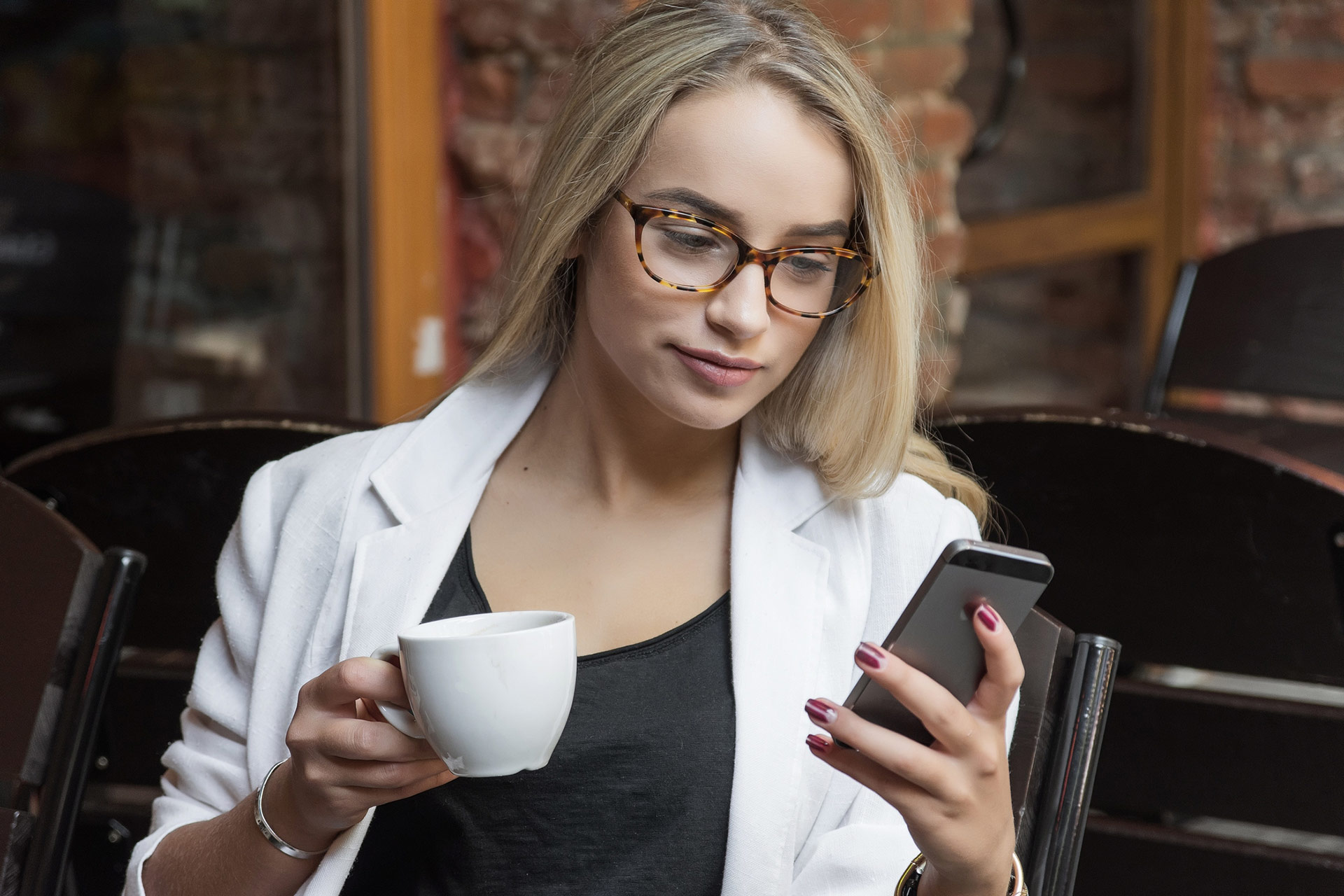 Junge Geschäftsfrau blond mit Brille im Café