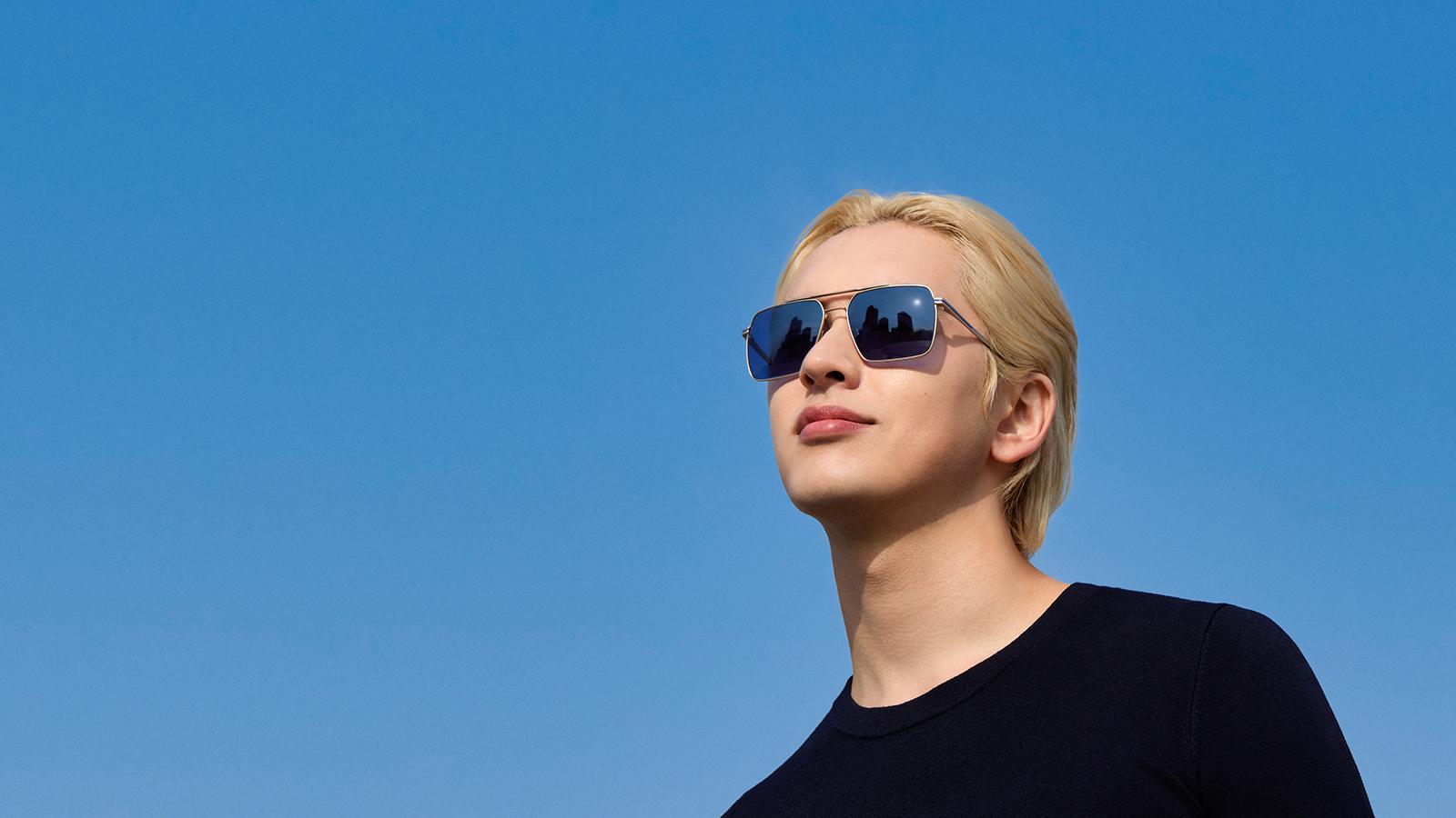 Junger Mann trägt Brille mit der neuen Sonnenschutzfarbe Nachtblau.