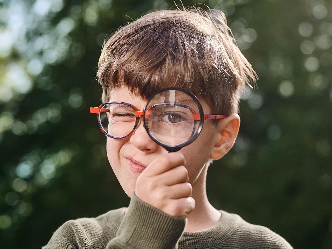 Junge mit Brille und Lupe