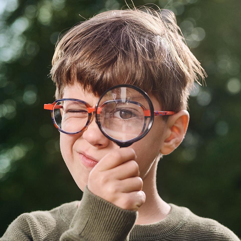 Junge mit Brille und Lupe