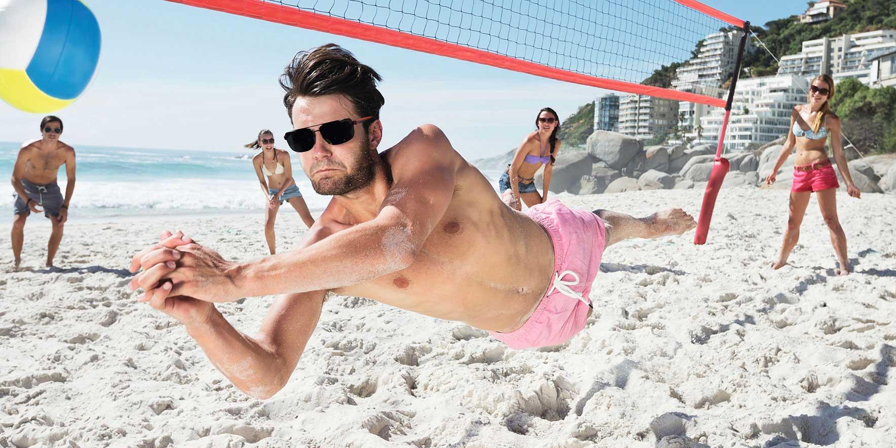 Menschen am Strand spielen Beachvolleyball