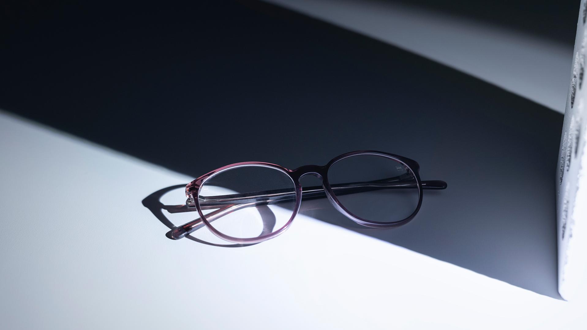 Brillen mit ZEISS Brillengläsern und DuraVision® Beschichtungen, die sich zur Hälfte im Schatten und zur Hälfte in der Sonne befinden.