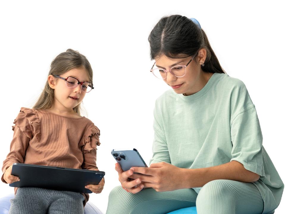 Zwei Mädchen schauen, wie empfohlen, aus einer Entfernung von mehr als 20 cm auf ein digitales Gerät.