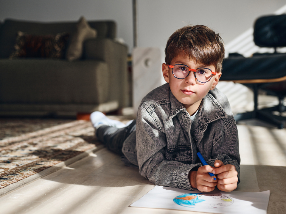 Ein kleiner Junge mit ZEISS MyoCare Brillengläsern blickt direkt in die Kamera.