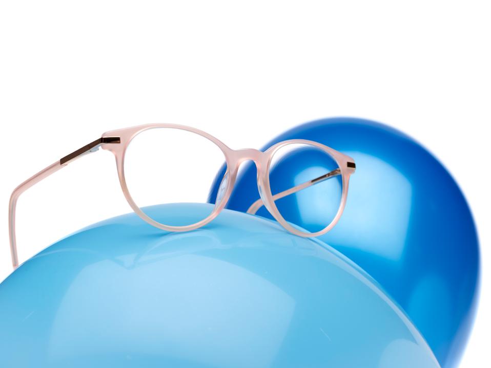 ZEISS MyoCare Brillengläser mit einer rosa Brillenfassung auf einem blauen Luftballon.