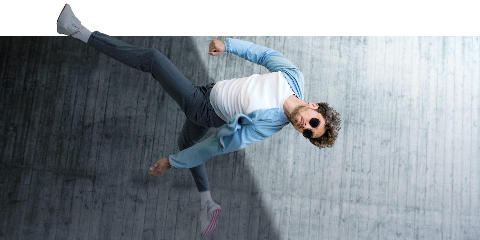  Ein Mann mit eingedunkelter ZEISS PhotoFusion X Brille springt in die Luft 