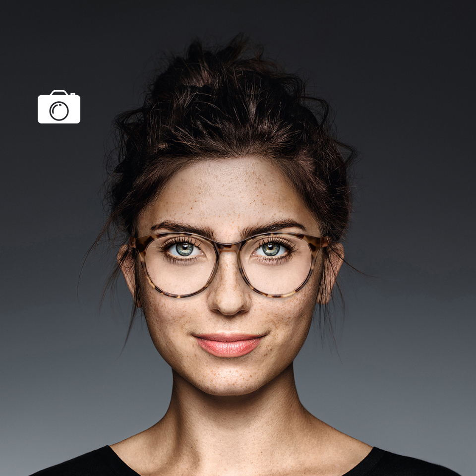 Ansicht derselben klare Brillengläser tragenden Frau durch eine normale Kamera und ein UV-Kameraobjektiv. Mit der UV-Kamera sieht das Brillenglas schwarz aus – ein Zeichen dafür, dass es keine UV-Strahlung durchlässt.  