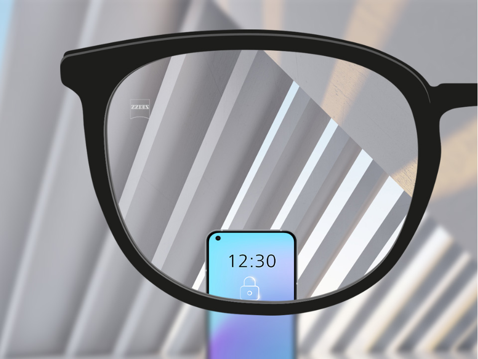 Abbildung mit Blick durch ein ZEISS SmartLife Einstärkenglas. Ein Smartphone ist zu sehen und das Brillenglas ist vollkommen klar. 