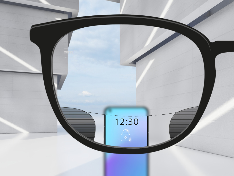 Abbildung mit Blick durch ein ZEISS SmartLife Digital Brillenglas. Ein Smartphone ist zu sehen. Das Brillenglas ist im oberen und unteren Brillenglasbereich vollkommen klar, links und rechts befinden sich kleine, unscharfe Flächen.