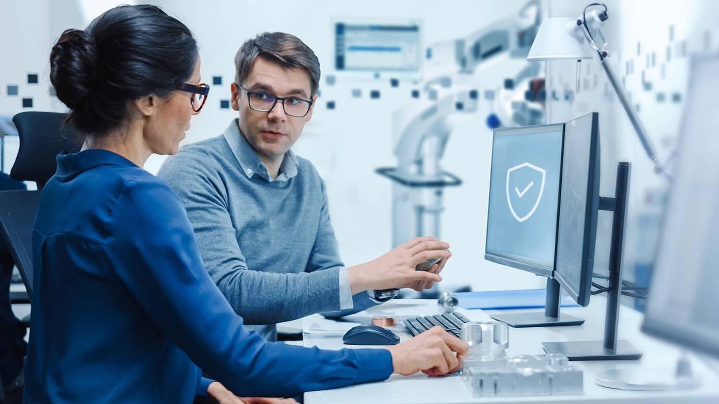 Zwei Fachleute besprechen die Arbeit an einem Computerarbeitsplatz in einer Hightech-Umgebung des Labors.