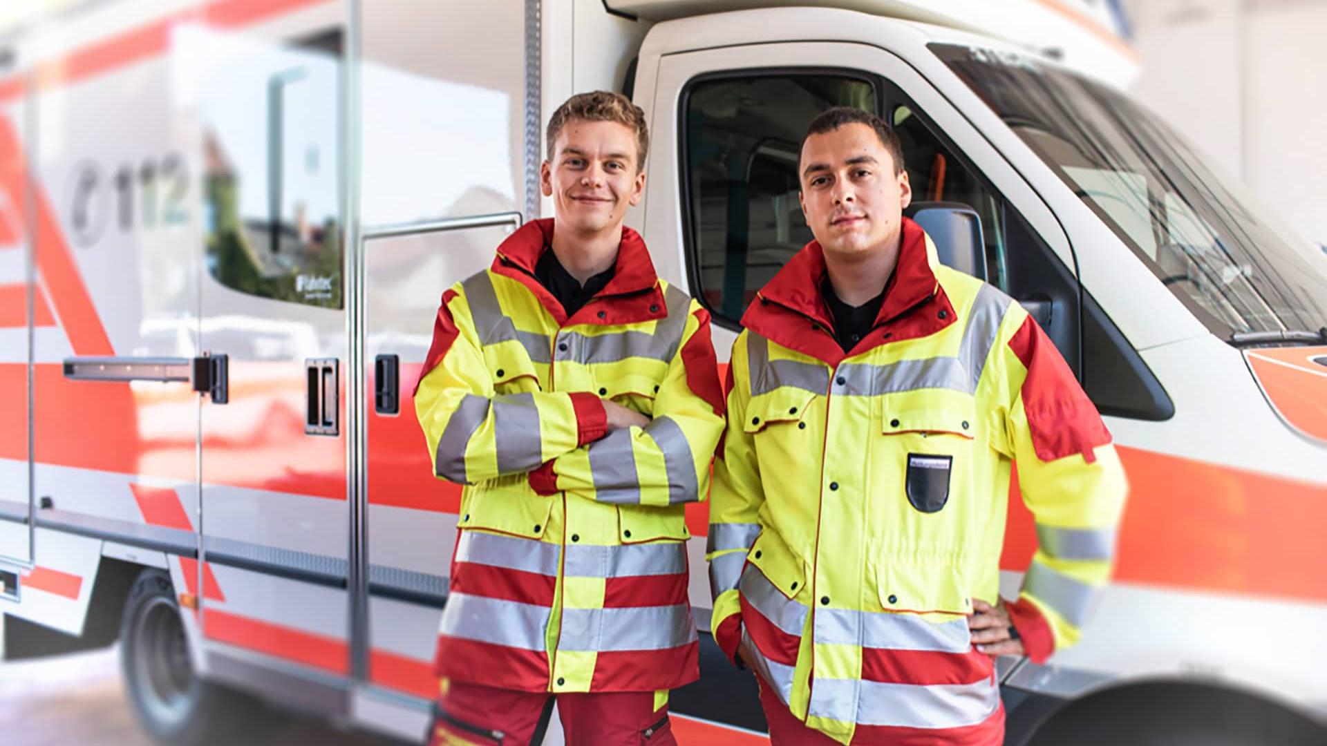 Zwei Sanitäter vor Rettungswagen