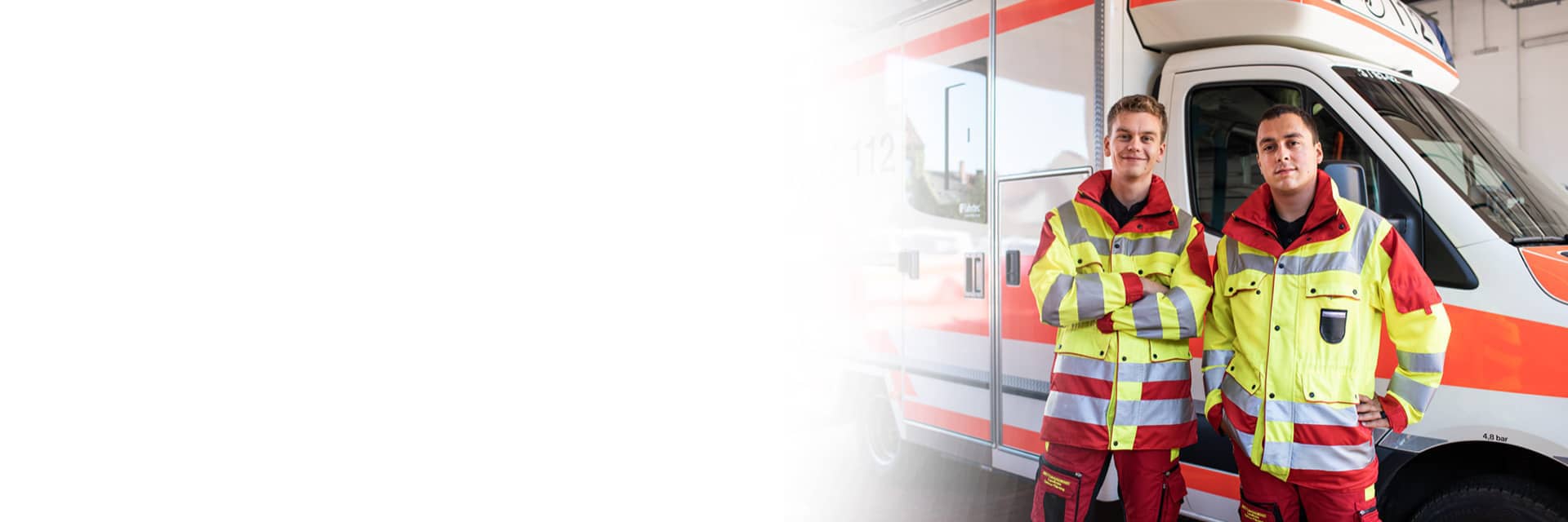 Zwei Sanitäter stehen vor einem Krankenwagen